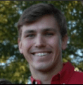 A man in red shirt smiling for the camera.