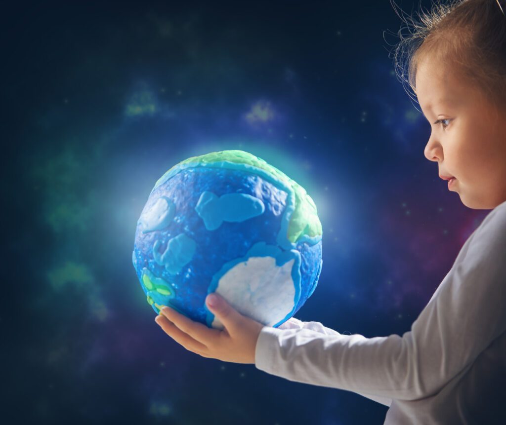 A child holding an earth globe in his hands.