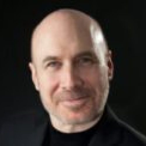 A bald man with a black shirt and jacket