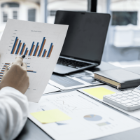 A person holding a paper with graphs on it